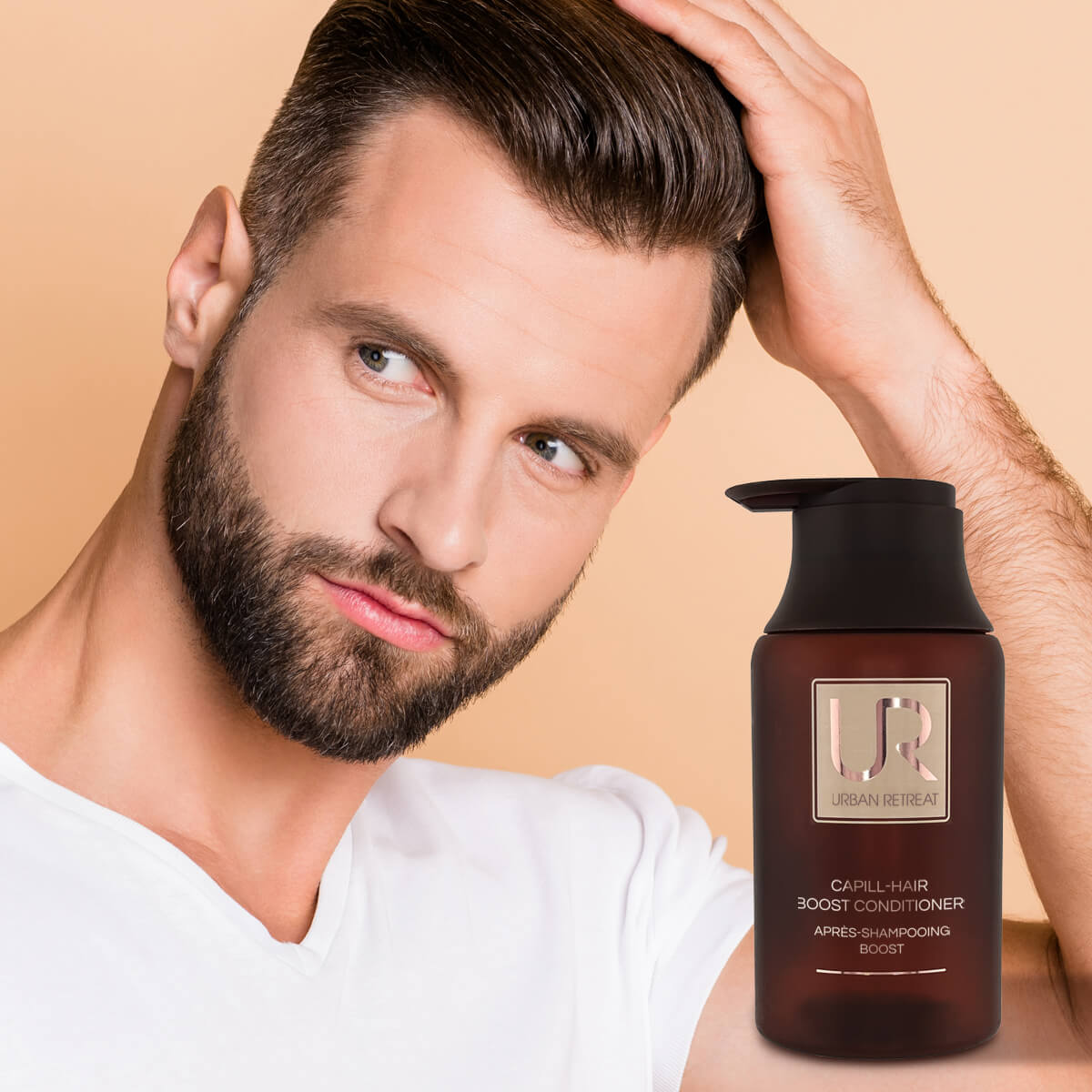 Man with a beard and styled hair next to a bottle of U.R. hair product on a beige background