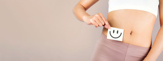 Person holding a card with a smiley face near their abdomen.