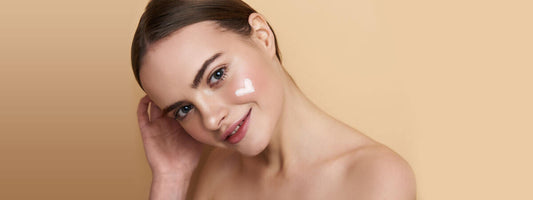 A smiling young woman with a smooth complexion against a beige background.